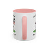 A white ceramic mug with a pink interior, pink handle, and a cartoon cow graphic with partial text on the side, shown on a plain white background.