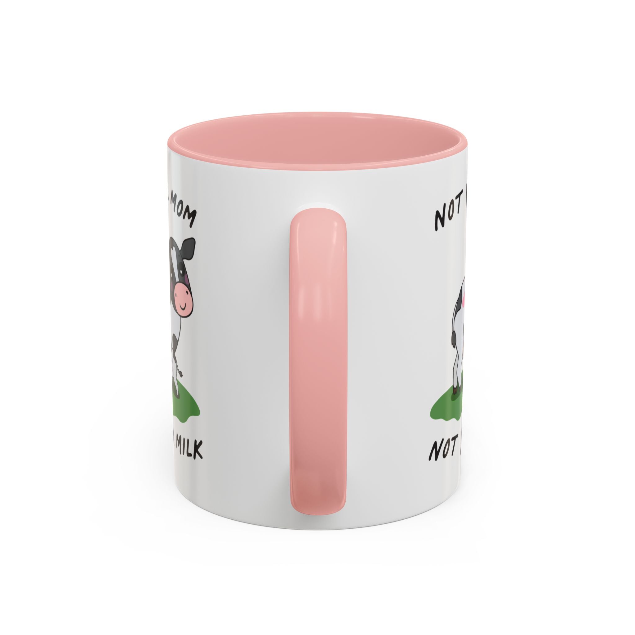 A white ceramic mug with a pink interior, pink handle, and a cartoon cow graphic with partial text on the side, shown on a plain white background.