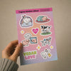 Vegan sticker sheet with Bo and Friends characters and 'Vegan Love' text held by a hand against a beige background