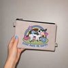 Beige pouch with a cow illustration and 'Cows Make Me Happy' text held by a hand against a plain background