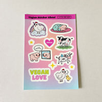 A rectangular vegan sticker sheet from Little Cow Shop featuring cute cartoon illustrations including a unicorn, sleeping pig, cow and calf, pig, chicken, and text stickers like 'VEGAN' and 'VEGAN LOVE' on a pink-to-blue gradient background.
