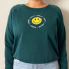 happy vegan smiley face on chest of organic green crew on model 